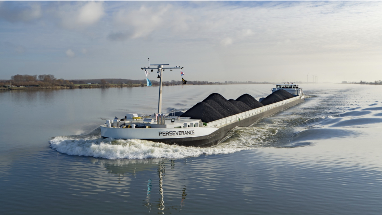 Bateau fluvial de vrac chargé sur un large fleuve