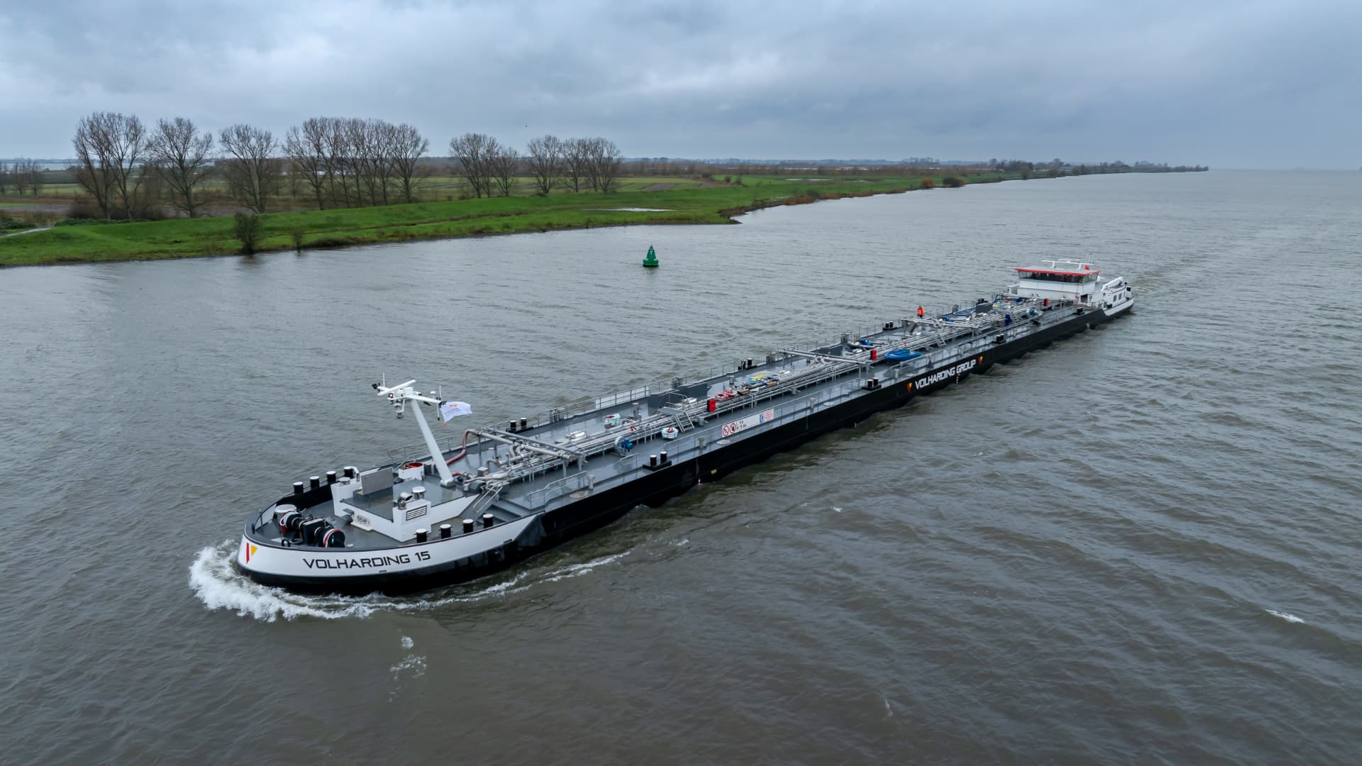 Inland tanker Volharding 15 sailing on a river, photographed from above